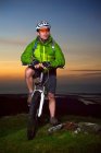 Гірський велосипедист стоїть на вершині пагорба — стокове фото