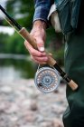 Man with fly fishing rod and reel, close up — Stock Photo