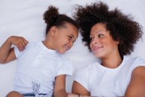 Mother and daughter laying on bed — Stock Photo