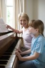 Дівчина і бабуся грають на піаніно — стокове фото
