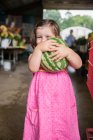 Portrait of girl holding watermelon at market — Stock Photo