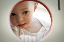 Little girl looking through circle — Stock Photo