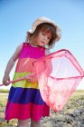 Girl examining fishing net outdoors — Stock Photo