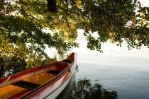 Canoe moored on lake at sunset time — Stock Photo