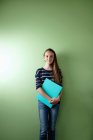 Schülerin hält Ringbuch vor grünem Hintergrund — Stockfoto