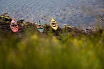 Kayaks docked on rocky beach — Stock Photo