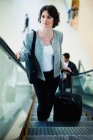 Businesswoman riding escalator, selective focus — Stock Photo