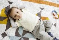 Portrait de bébé garçon allongé sur une couverture, vue aérienne — Photo de stock
