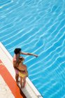 Giovane coppia in piedi a bordo piscina — Foto stock
