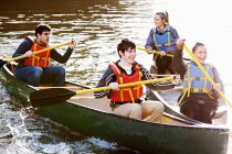 Друзі веслують каное на нерухомому озері — стокове фото