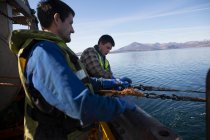 Pescador liberando red en el mar, Isla de Skye, Escocia - foto de stock