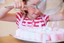 Girl dusting candies with sugar — Stock Photo