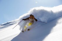 Esquiador va cuesta abajo en las montañas - foto de stock