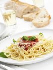 Tigela de espaguete com molho de tomate, manjericão e queijo — Fotografia de Stock