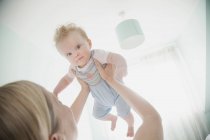 Mother holding baby daughter in air — Stock Photo