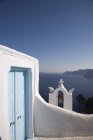 Vista da entrada azul da igreja e da torre do sino, Oia, Santorini, Cyclades, Greece — Fotografia de Stock