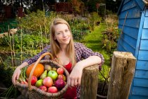 Mujer recogiendo verduras en el jardín - foto de stock