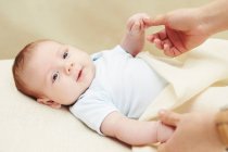 Gros plan de bébé garçon tenant les mains de la mère — Photo de stock