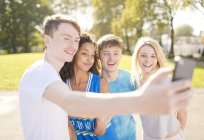 Quatre jeunes joueurs de basket-ball adultes posant pour smartphone selfie — Photo de stock