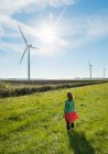 Mulher madura em pé no campo, assistindo turbinas eólicas no parque eólico, visão traseira, Rilland, Zelândia, Países Baixos — Fotografia de Stock