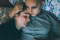 Вид сверху на молодую лесбийскую пару лежащую на кровати — стоковое фото