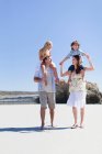 Parents carrying children on shoulders — Stock Photo