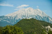 Church on hill in front of mountains — Stock Photo