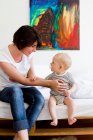 Mother and baby sitting on couch — Stock Photo