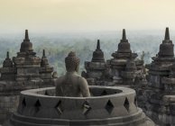 Buda y tejados, El templo budista de Borobudur, Java, Indonesia - foto de stock