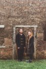 Portrait of couple in front of old brick wall door frame — Stock Photo