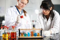 Двоє студентів хімії проводять експеримент — стокове фото
