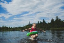 Girl with rubber ring jumping in Indian river, Ontario, Canada — Stock Photo