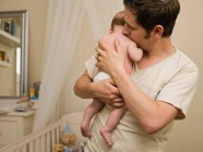 Un padre sosteniendo a su bebé recién nacido - foto de stock