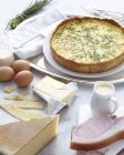 Still life of cooked quiche and raw ingredients — Stock Photo