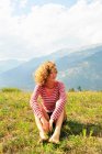 Mujer sentada en una colina rural - foto de stock