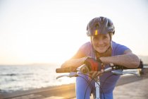 Старша жінка на велосипеді на пляжі — стокове фото