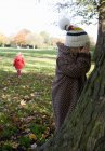 Girls playing hide and seek in park, Londres, Inglaterra, Reino Unido — Fotografia de Stock