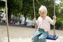 Bebê menina no balanço no parque — Fotografia de Stock