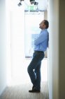 Mature man leaning against wall in corridor — Stock Photo
