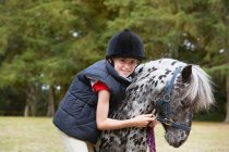 Young girl with pony outdoors — Stock Photo