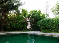 Fille sauter dans la piscine — Photo de stock