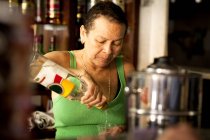 Mujer sirviendo licor en el bar - foto de stock