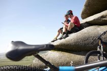 Cyclists resting on rocky outcrop — Stock Photo
