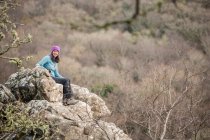 Donna matura seduta su rocce, ritratto — Foto stock