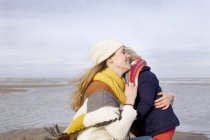 Femme adulte moyenne embrassant sa fille sur la plage, Bloemendaal aan Zee, Pays-Bas — Photo de stock