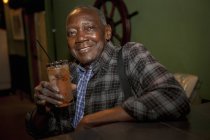 Portrait of senior man drinking cocktail in bar, Rio De Janeiro, Brazil — Stock Photo