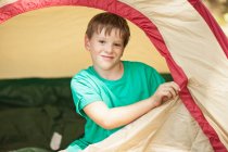Boy zipping camp tent closed — Stock Photo