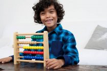 Boy playing with abacus — Stock Photo