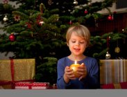 Garçon tenant bougie à Noël — Photo de stock