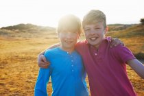 Dos chicos con los brazos alrededor uno del otro - foto de stock